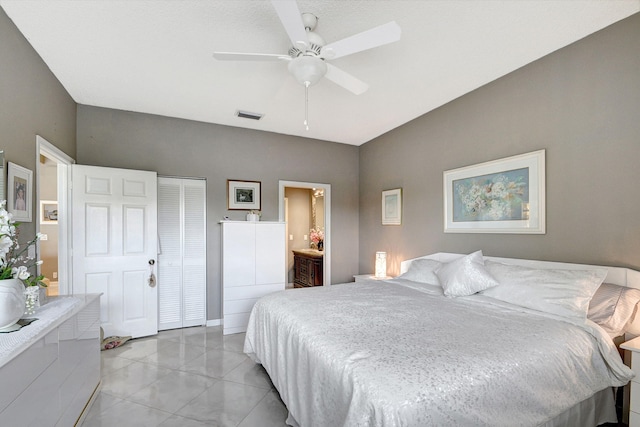 bedroom featuring ensuite bathroom, ceiling fan, and a closet