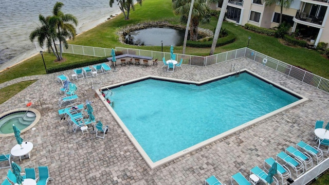 view of pool featuring a patio, a water view, and a community hot tub