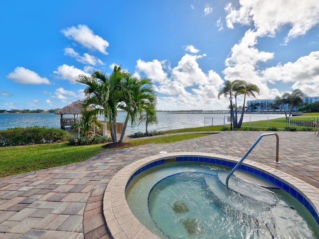 view of pool featuring an in ground hot tub and a water view