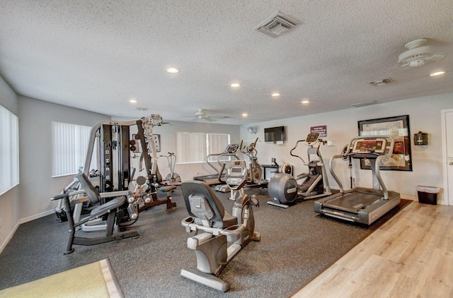 gym featuring hardwood / wood-style floors and a textured ceiling