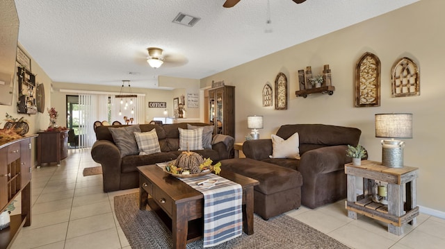 living room featuring light tile patterned floors, a textured ceiling, and ceiling fan