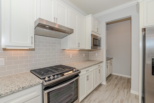 kitchen featuring white cabinetry, crown molding, light stone counters, and appliances with stainless steel finishes