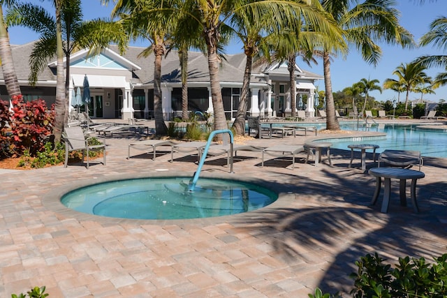 view of swimming pool featuring a patio and a hot tub