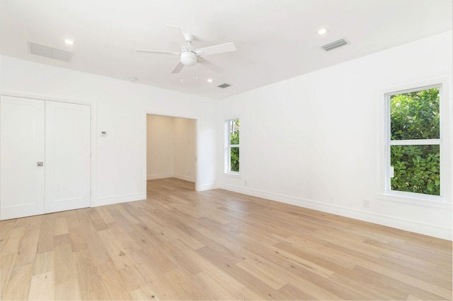 unfurnished bedroom with ceiling fan, a closet, and light wood-type flooring