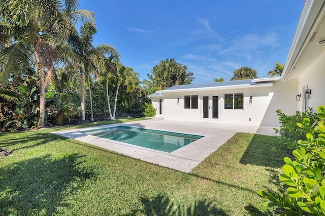 view of swimming pool with french doors, a yard, and a patio