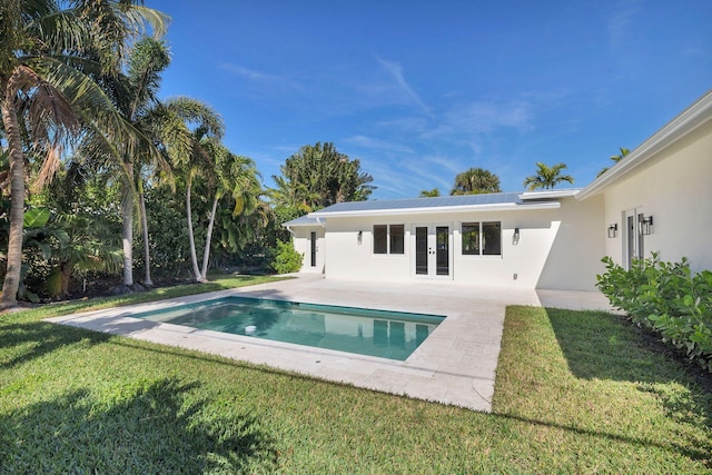 view of swimming pool with french doors, a yard, and a patio area