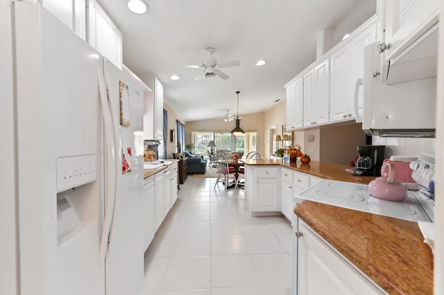 kitchen featuring vaulted ceiling, white refrigerator with ice dispenser, hanging light fixtures, white cabinetry, and light tile patterned flooring