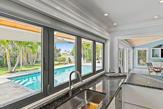 entryway with crown molding, lofted ceiling, sink, and a wealth of natural light