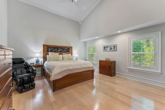 bedroom featuring high vaulted ceiling, light hardwood / wood-style flooring, and crown molding