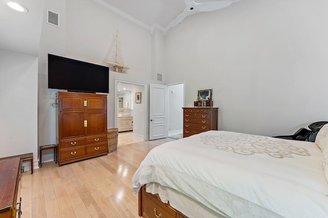 bedroom with light hardwood / wood-style floors, connected bathroom, ornamental molding, high vaulted ceiling, and ceiling fan