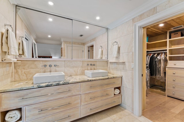 bathroom featuring crown molding, vanity, tile walls, and backsplash