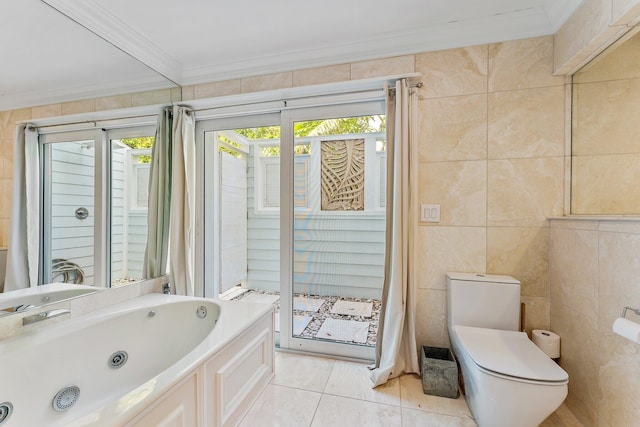 bathroom featuring ornamental molding, tile patterned floors, a washtub, toilet, and tile walls