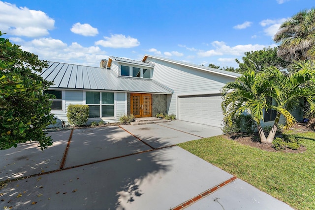 view of front of house with a garage, a front lawn, and french doors