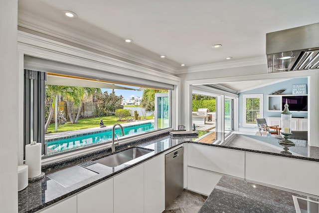 kitchen featuring dark stone counters, white cabinets, dishwasher, sink, and crown molding