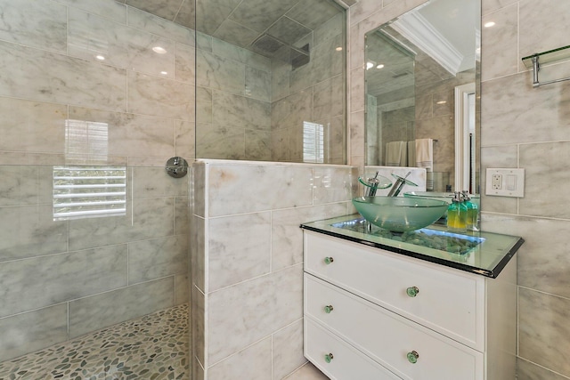 bathroom with tile walls, vanity, and a tile shower