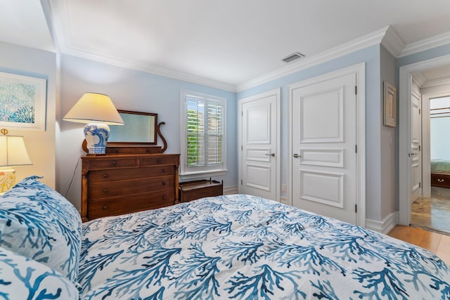 bedroom with crown molding, a closet, and light wood-type flooring