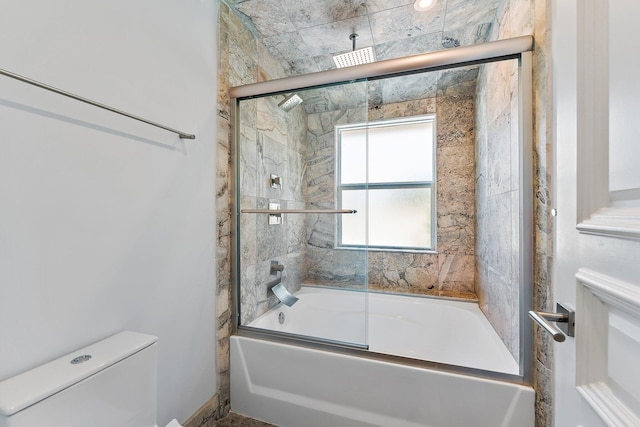 bathroom with bath / shower combo with glass door and toilet