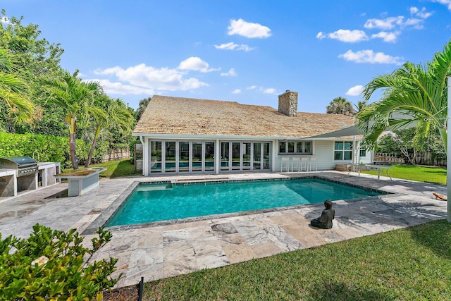 view of swimming pool with an outdoor kitchen, grilling area, and a patio