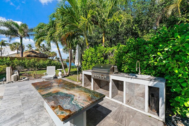 view of patio / terrace with exterior kitchen and a grill