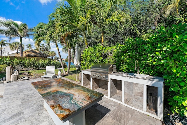 view of patio / terrace featuring exterior kitchen and a grill