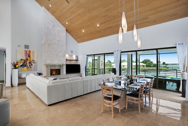 dining area featuring a fireplace, wood ceiling, and high vaulted ceiling