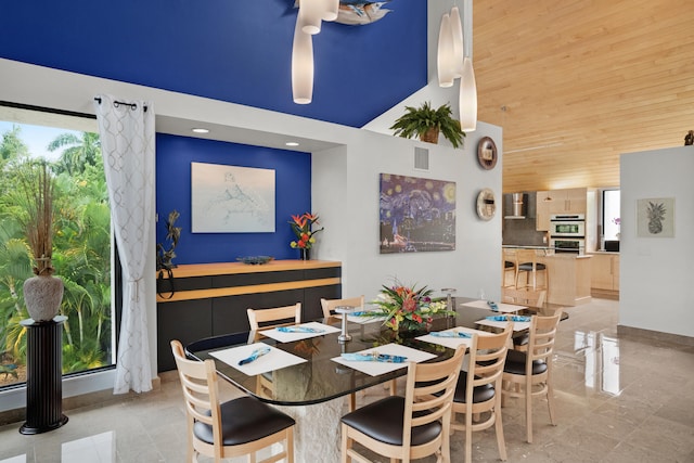 dining space featuring a high ceiling and wooden ceiling