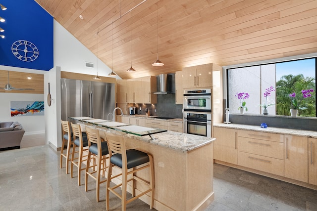 kitchen featuring a center island with sink, a kitchen bar, wall chimney exhaust hood, high vaulted ceiling, and wood ceiling