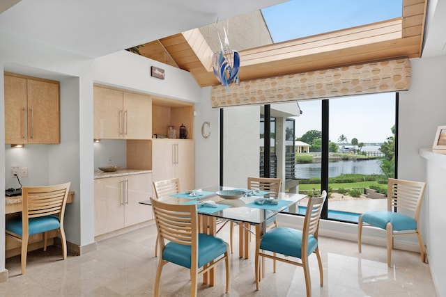 dining room with wood ceiling, a water view, and vaulted ceiling with skylight