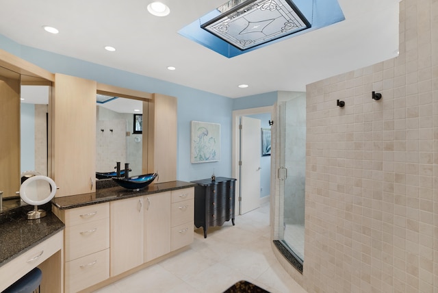 bathroom featuring a shower with shower door, vanity, and tile patterned flooring