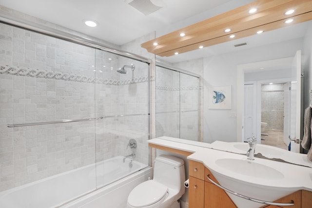 full bathroom with shower / bath combination with glass door, vanity, and toilet