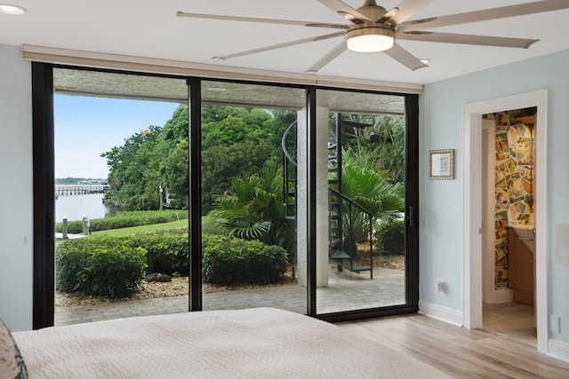 unfurnished bedroom with access to outside, ensuite bath, light hardwood / wood-style floors, a water view, and ceiling fan