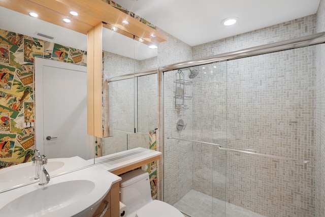 bathroom featuring an enclosed shower, vanity, and toilet