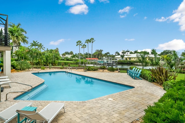 view of pool with a water view and a patio area