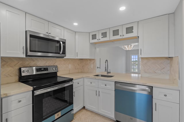 kitchen featuring backsplash, white cabinetry, sink, and stainless steel appliances