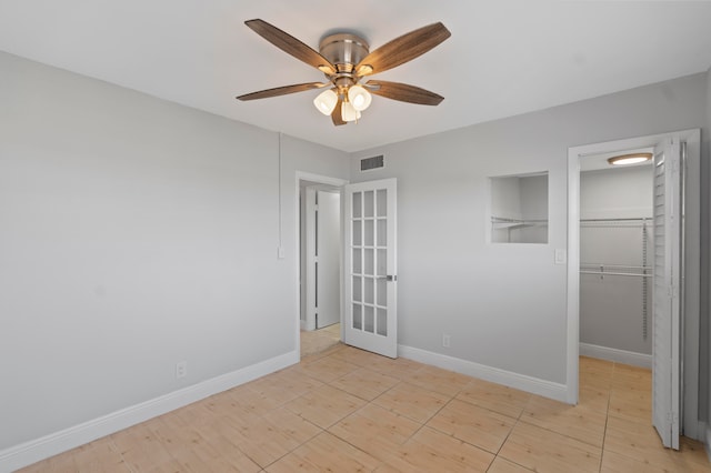 unfurnished room with ceiling fan and french doors