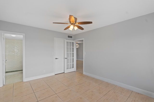 spare room with ceiling fan and french doors