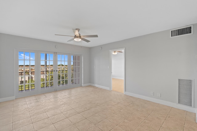 tiled spare room featuring french doors and ceiling fan