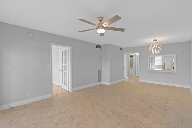 tiled empty room featuring ceiling fan with notable chandelier