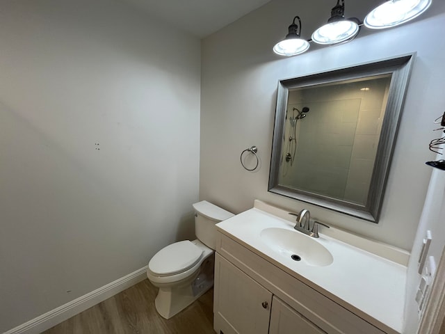 bathroom featuring a shower, hardwood / wood-style floors, vanity, and toilet