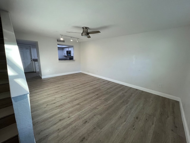 unfurnished living room with ceiling fan, wood-type flooring, and track lighting