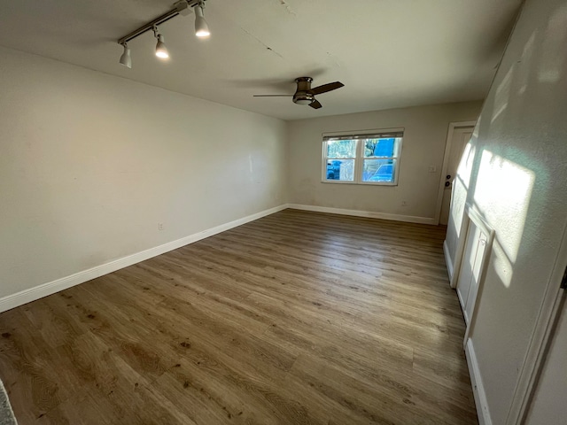 spare room with ceiling fan, light hardwood / wood-style flooring, and rail lighting