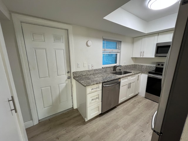 kitchen with light hardwood / wood-style floors, sink, white cabinetry, and stainless steel appliances