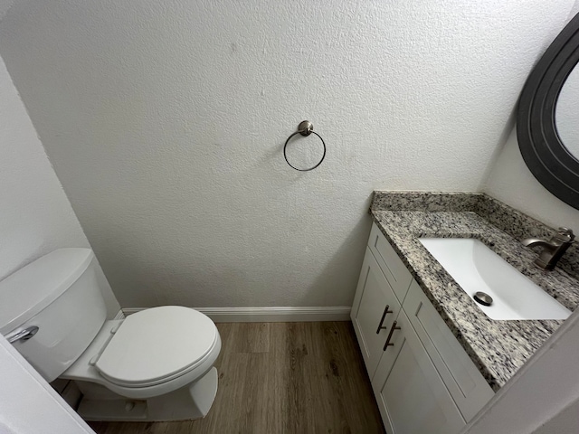 bathroom featuring vanity, hardwood / wood-style flooring, and toilet