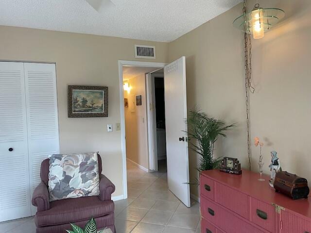 living area with light tile patterned floors and a textured ceiling