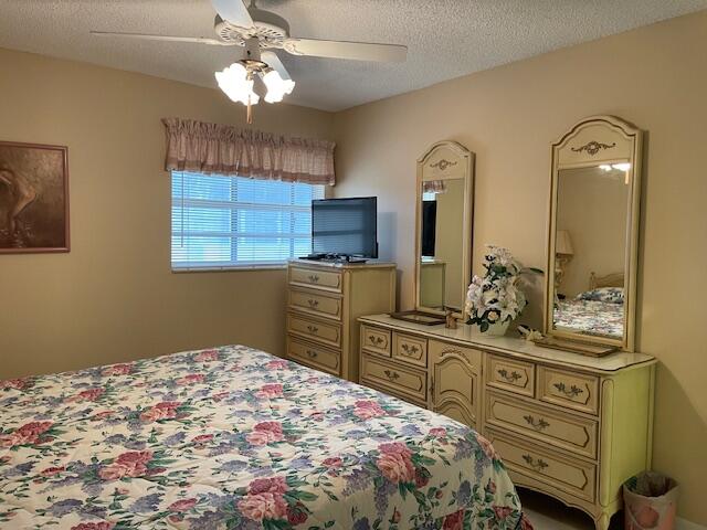 bedroom featuring a textured ceiling and ceiling fan