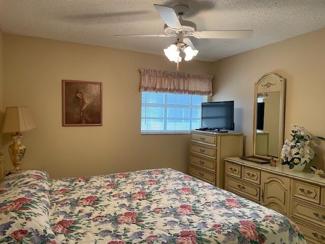 bedroom featuring ceiling fan and a textured ceiling