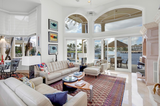 living room featuring a water view, a chandelier, and a high ceiling