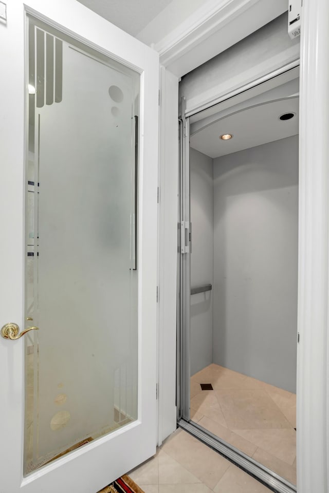 bathroom with tile patterned flooring and elevator