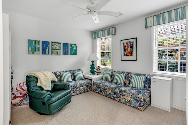 living room featuring ceiling fan, carpet floors, and a wealth of natural light