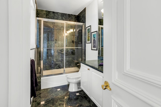 full bathroom featuring vanity, toilet, and bath / shower combo with glass door